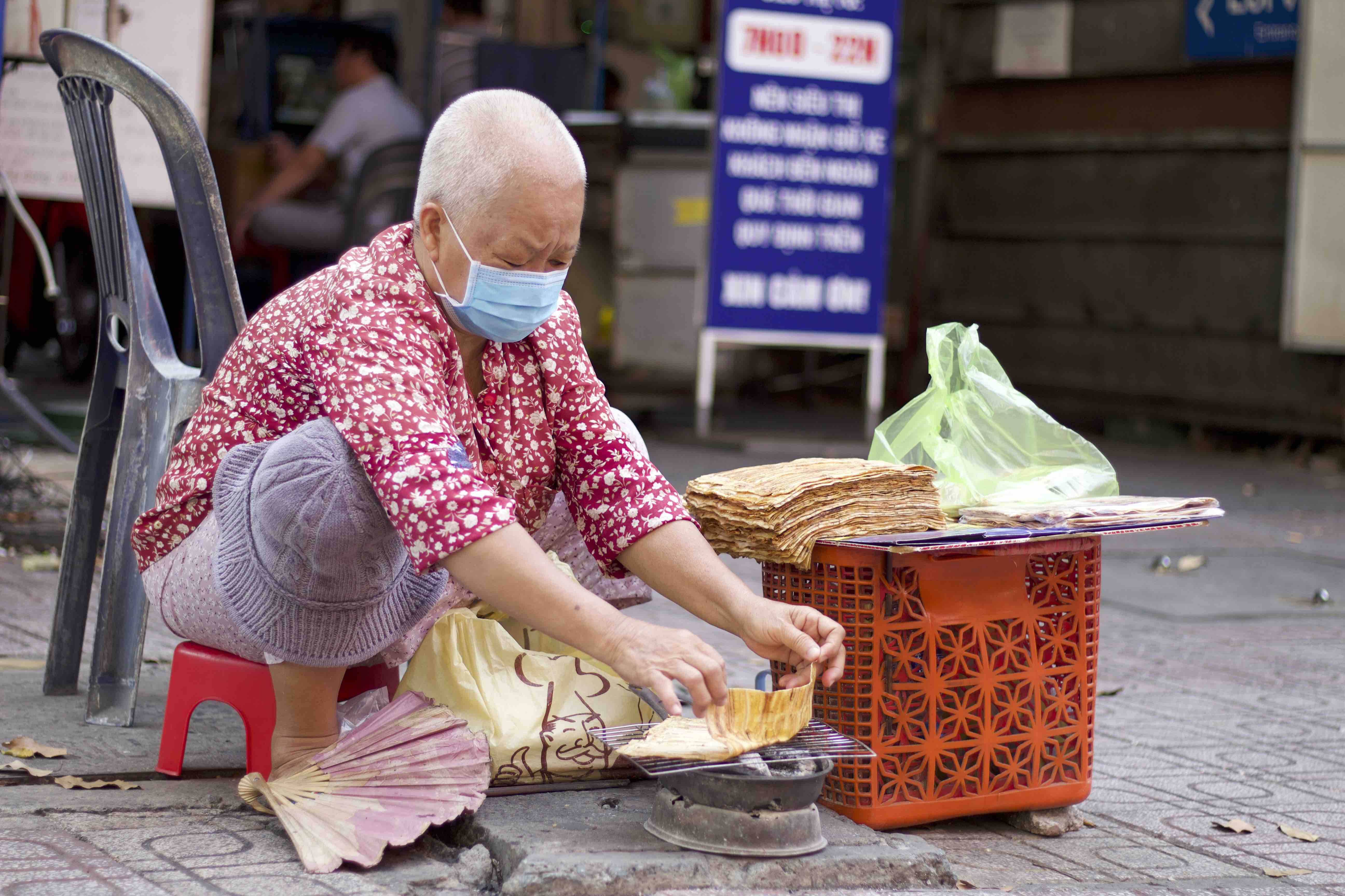 Nguyen Thi Loi grills banh chuoi nuong at her stall near Coopmart Nguyen Dinh Chieu supermarket in District 3, Ho Chi Minh City. Photo: Linh To / Tuoi Tre