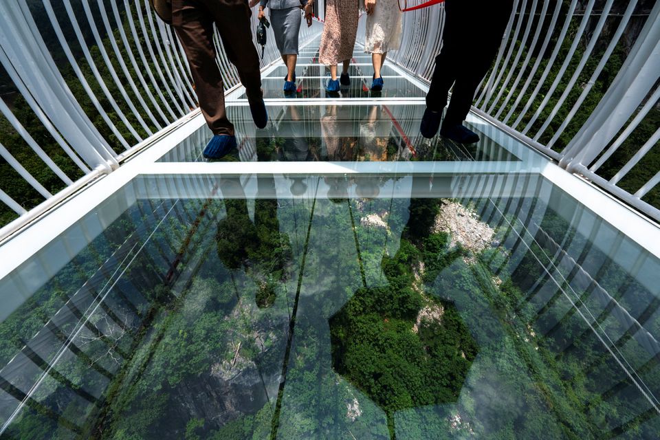 People walk on the Bach Long glass bridge during the opening ceremony at Moc Chau district in Son La province, Vietnam, May 28, 2022. Picture taken May 28, 2022. Photo: Reuters