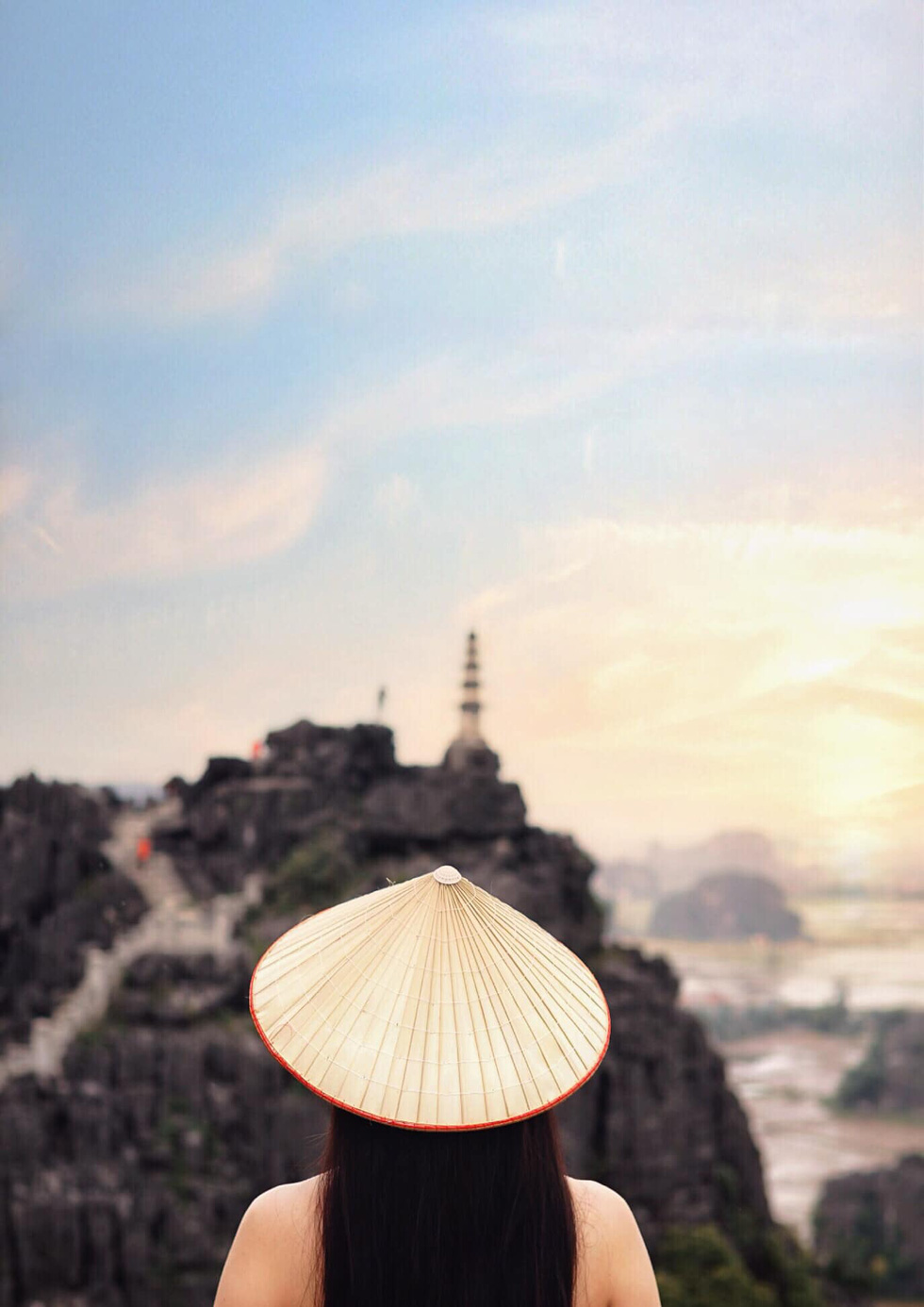 A vistor poses for a photo against the background of Hang Mua (Mua Cave) in Ninh Binh Province, Vietnam. Photo: Tiem anh 23.4 / Handout via Tuoi Tre