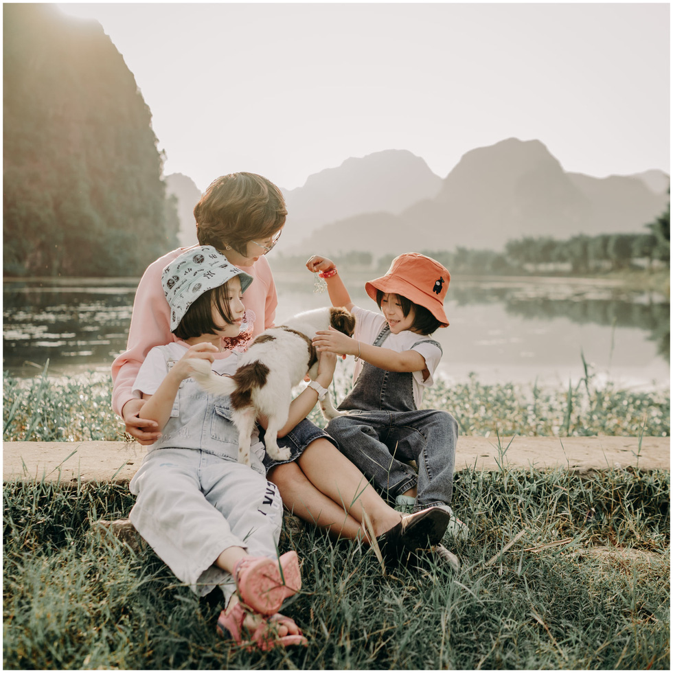 A woman and her children pose for a photo against the mountainous landscape background at Trang An Scenic Landscape Complex in Ninh Binh Province, Vietnam. Photo: Tiem anh 23.4 / Handout via Tuoi Tre