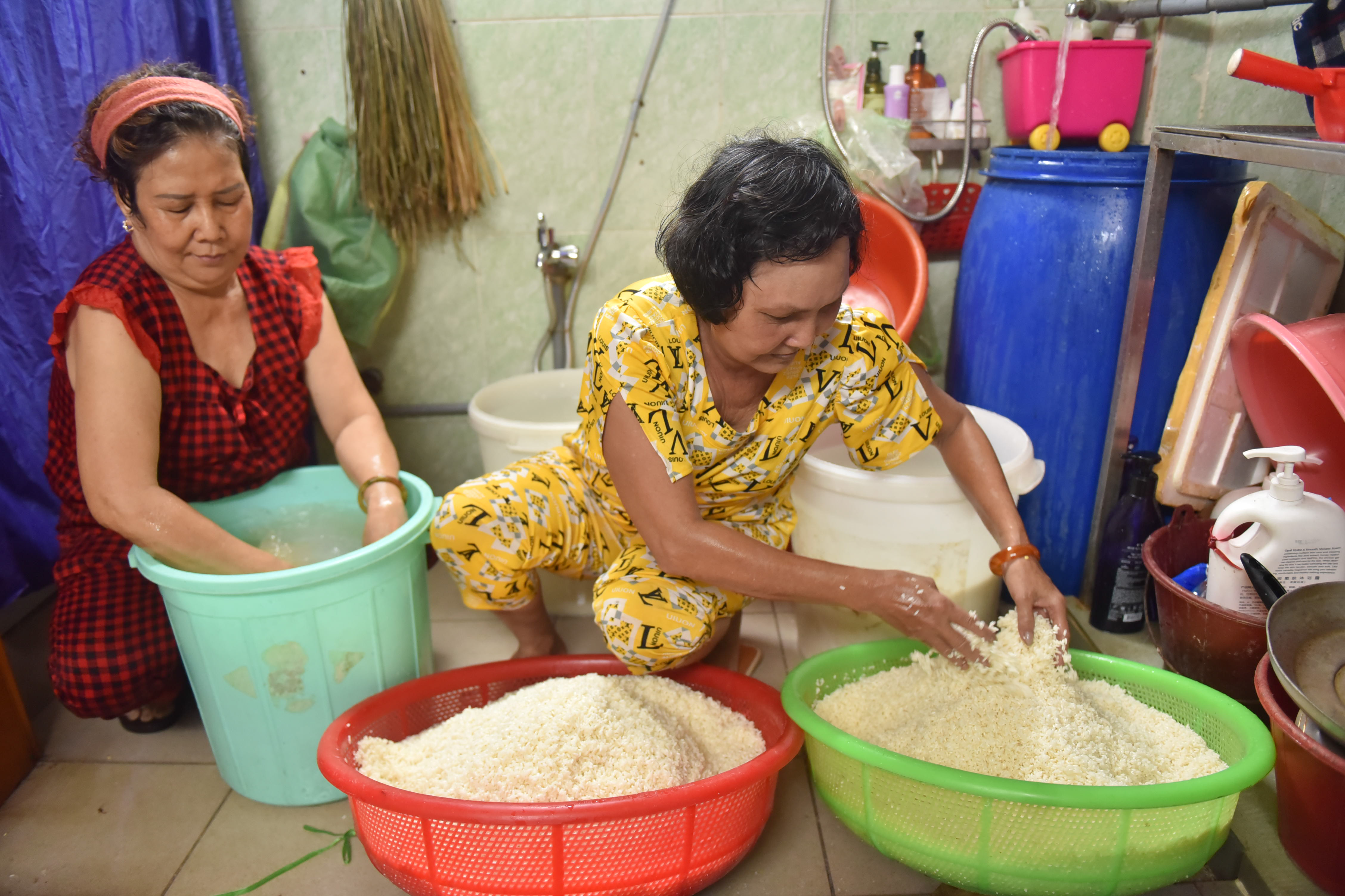 Tran Cam Thao (left), owner of An Ky Banh Chung shop, and a staff member prepare glutinous rice to make zongzi for the 2022 Duanwu Festival at her shop in District 11, Ho Chi Minh City. Photo: Ngoc Phuong / Tuoi Tre
