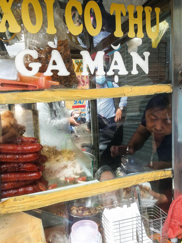 Thu serves 'xoi ga' for her customer at her stall in District 1, Ho Chi Minh City. Photo: Minh Duc / Tuoi Tre