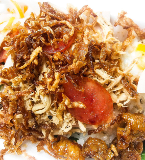 A dish of xoi ga topped with pork floss, xa bau (Chinese radish), lap xuong (Chinese sausage) and shredded chicken. Photo: Minh Duc / Tuoi Tre