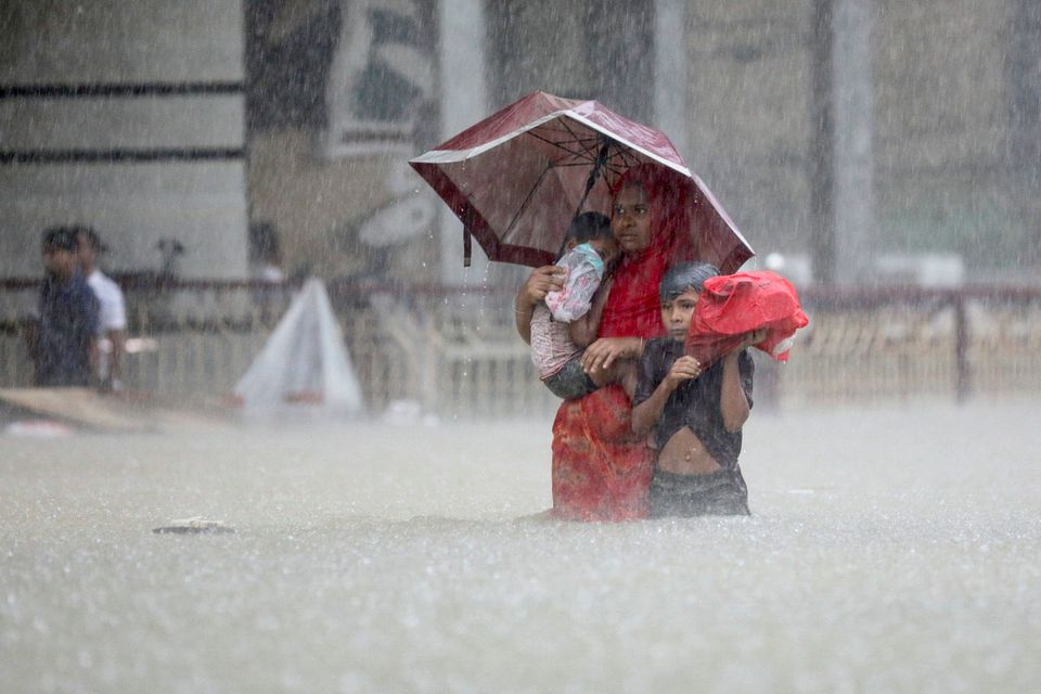 People wade through the water as they look for shelter during a flood, amidst heavy rains that caused widespread flooding in the northeastern part of the country, in Sylhet, Bangladesh, June 18, 2022. Photo: Reuters