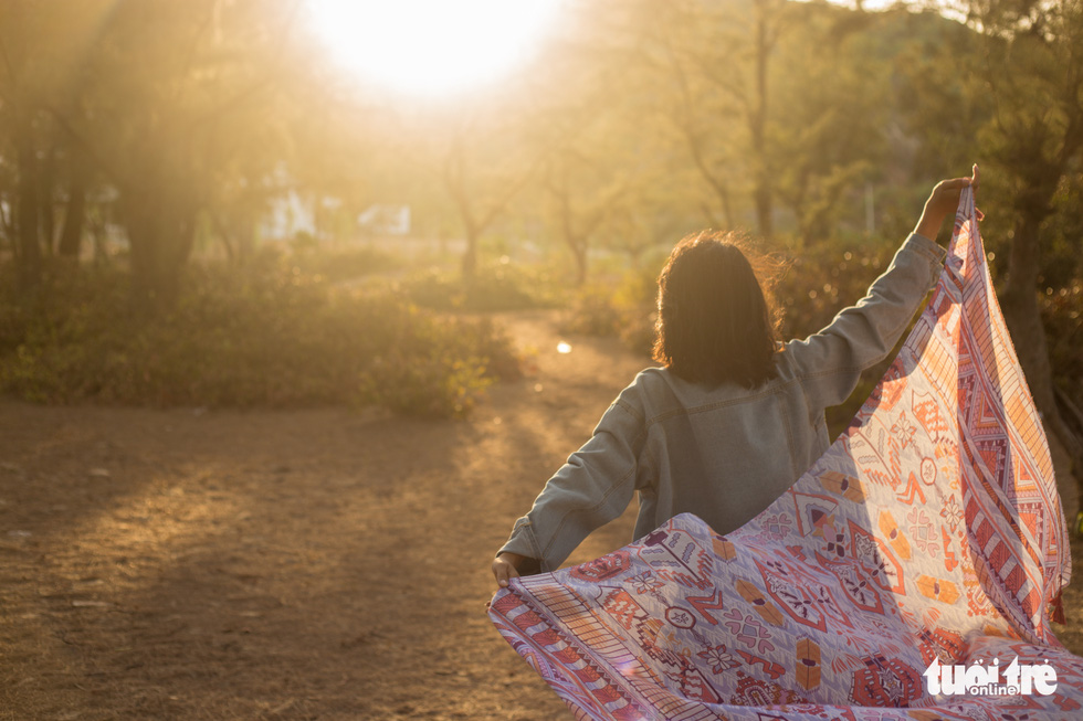 A visitor poses for a photo during sunset at the coastal she-oak forest at Cat Hai beach, in Quy Nhon City, Binh Dinh Province, south-central Vietnam. Photo: Nguyen Hien / Tuoi Tre