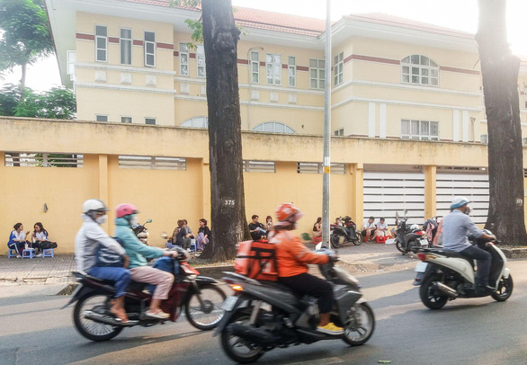 Customers crowd the sidewalk to enjoy ‘dua tac’ on Pasteur Street, District 3, Ho Chi Minh City. Photo: Minh Duc / Tuoi Tre