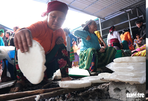 Vang Thi Mi grills ‘banh ngo nep’ on a wood stove at a market fair in Dong Van Town, Ha Giang Province, Vietnam. Photo: Ha Thanh / Tuoi Tre