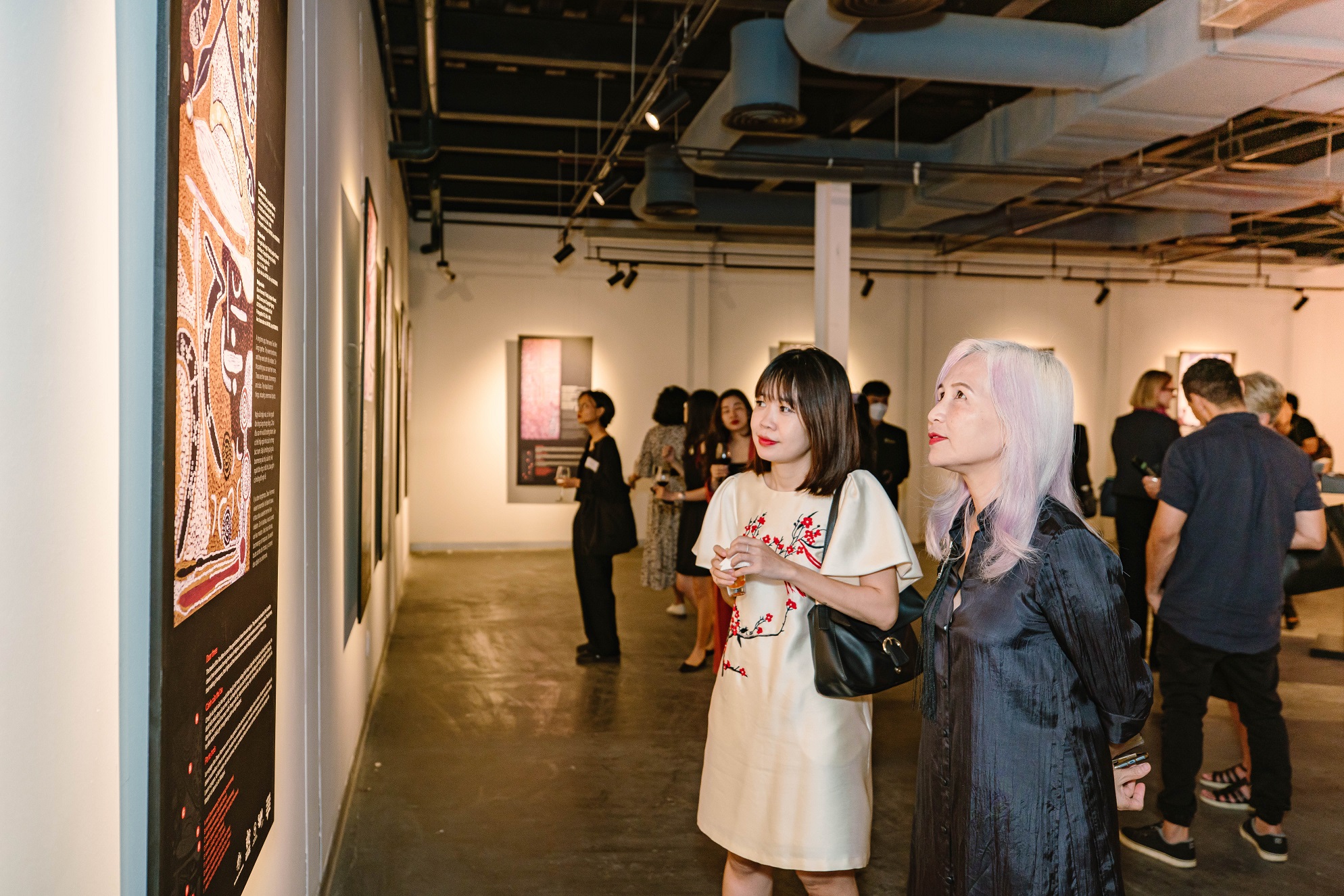 Guests contemplate an art work the Yuendumu Doors exhibition in Ho Chi Minh City. Photo: Consulate General of Australia in Ho Chi Minh City