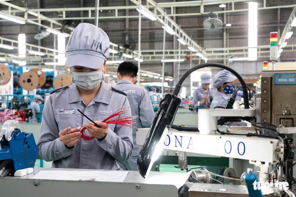 Employees of THACO in Quang Nam Province are at work in an area for automatic electric wire cuts. Photo: Huu Hanh / Tuoi Tre
