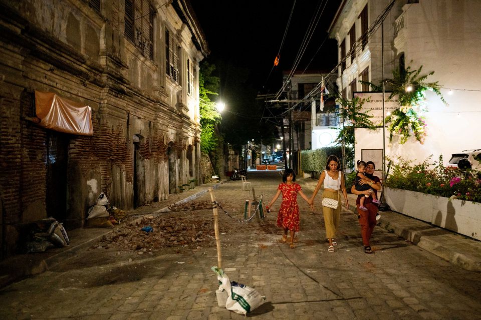 People walk past debris from a damaged building following an earthquake in Vigan City, Ilocos Sur, Philippines, July 27, 2022. Photo: Reuters