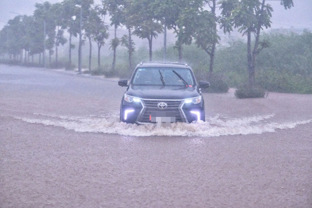 A car travels on flooded Co Linh Street in Hanoi, August 12, 2022. Photo: Pham Nam Tran / Tuoi Tre