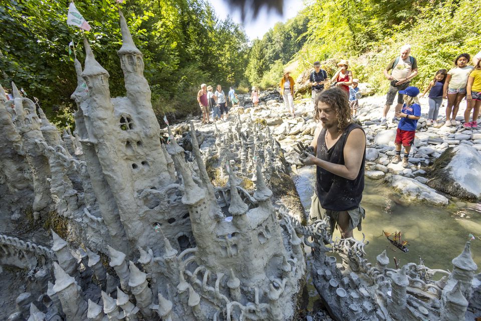 Land art artist Francois Monthoux works on his 'Monthoux castle' made out of clay retrieved from the dried bed of Le Toleure river due to ongoing drought, in Saubraz, Switzerland, August 12, 2022. Photo: Reuters
