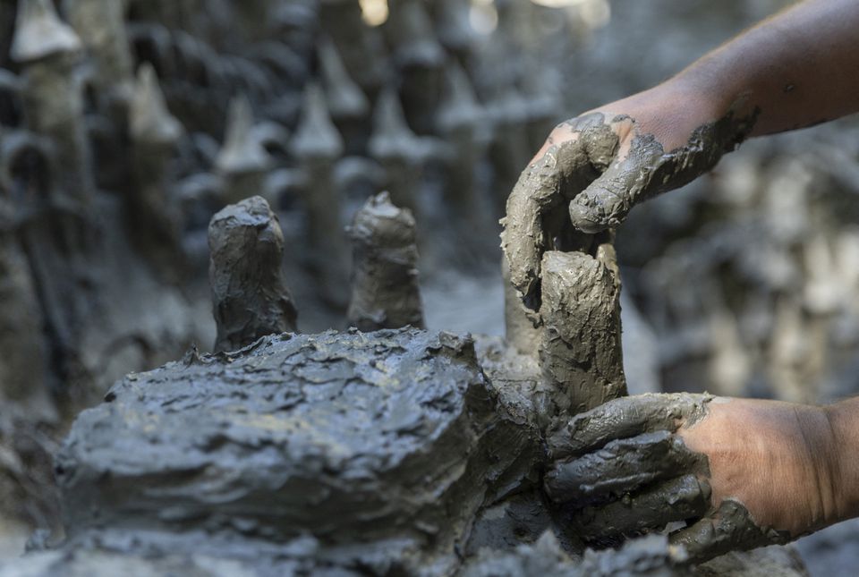Land art artist Francois Monthoux works on his 'Monthoux castle' made out of clay retrieved from the dried bed of Le Toleure river due to ongoing drought, in Saubraz, Switzerland, August 12, 2022. Photo: Reuters