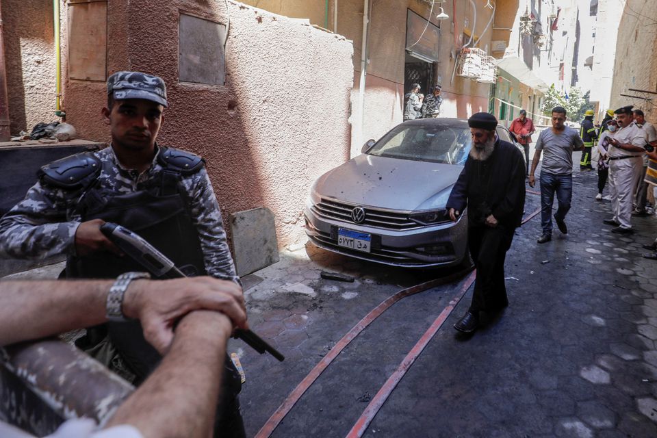 People and policemen gather near the scene where a deadly fire broke out at the Abu Sifin church in Giza, Egypt, August 14, 2022. Photo: Reuters
