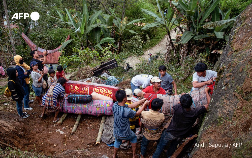 Coffins holding the preserved bodies of their loved ones are pulled from a burial cave carved into the mountainside. Photo: AFP