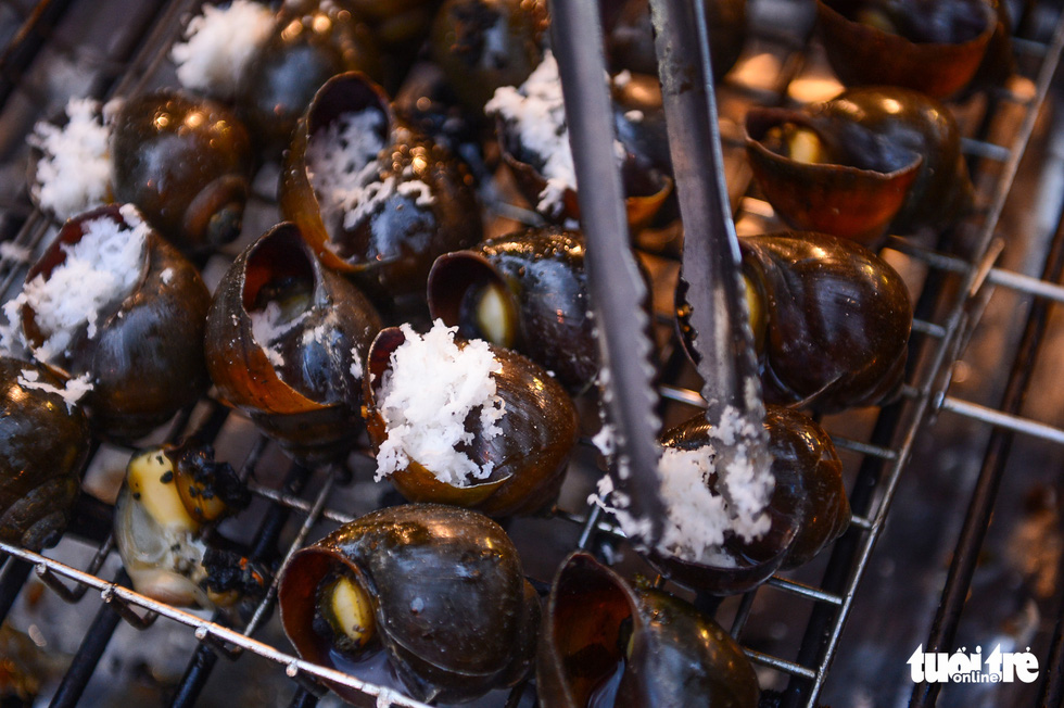 ‘Oc buou nuong dua’ (Vietnamese escargot grilled with shredded coconut) at Le hoi Van hoa am thuc, mon ngon 2022 in Van Thanh Tourist Park, Binh Thanh District, Ho Chi Minh City, on August 25, 2022. Photo: Quang Dinh / Tuoi Tre
