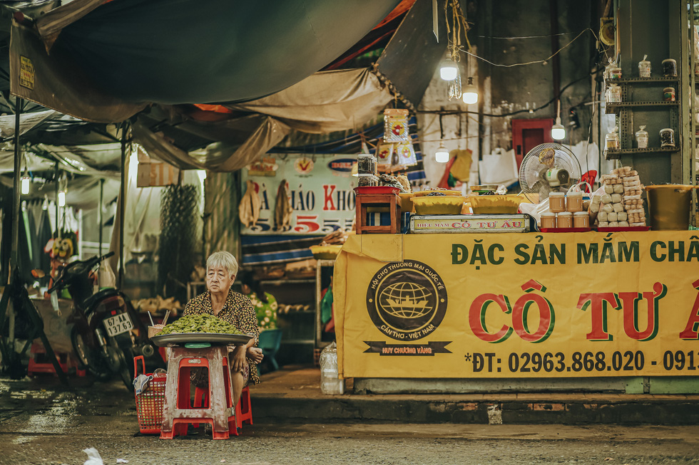An old woman sells ca na (elaeocarpus hygrophilus), an unforgettable dish with the taste of somewhat sour and acrid. This is a popular kind of fruit in Mekong Delta and is used to make sweet and savory snacks. Photo: Ky Anh / Tuoi Tre