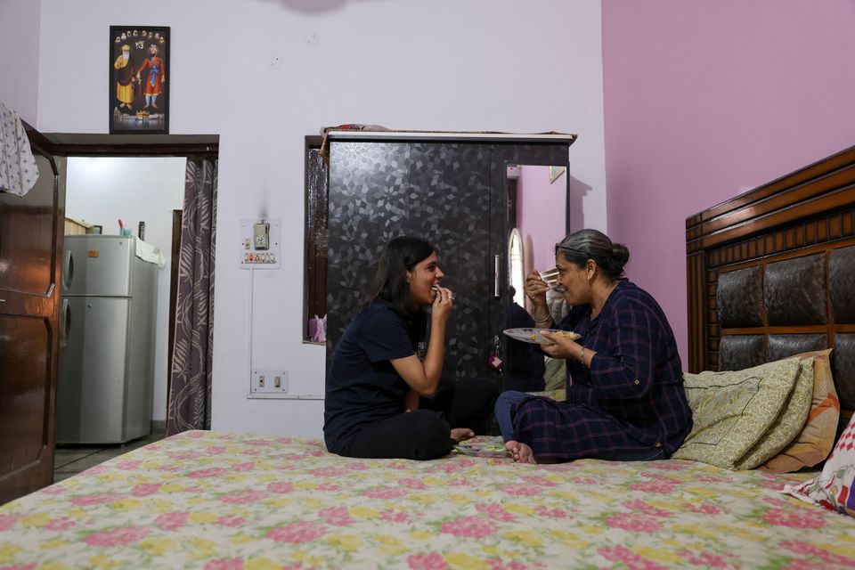 Jashandeep Kaur, 22, talks to her mother Ripudaman Kaur, 52, as they eat at their house in Dera Bassi, India, August 14, 2022. Photo: Reuters