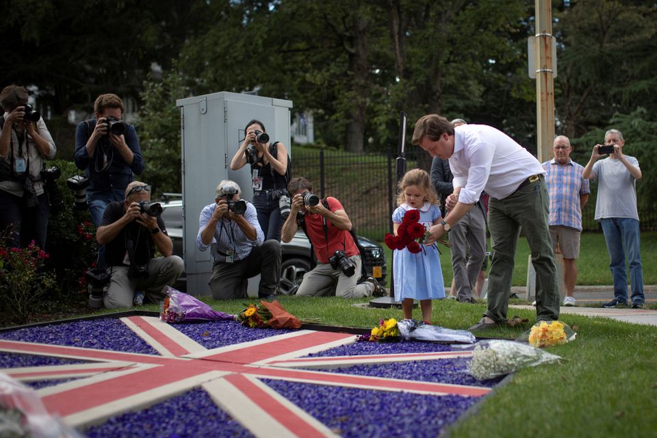 Edward Rodgers helps his daughter, India, lay flowers following the announcement of the death of Queen Elizabeth, at the British Embassy in Washington, U.S., September 8, 2022. Photo: Reuters