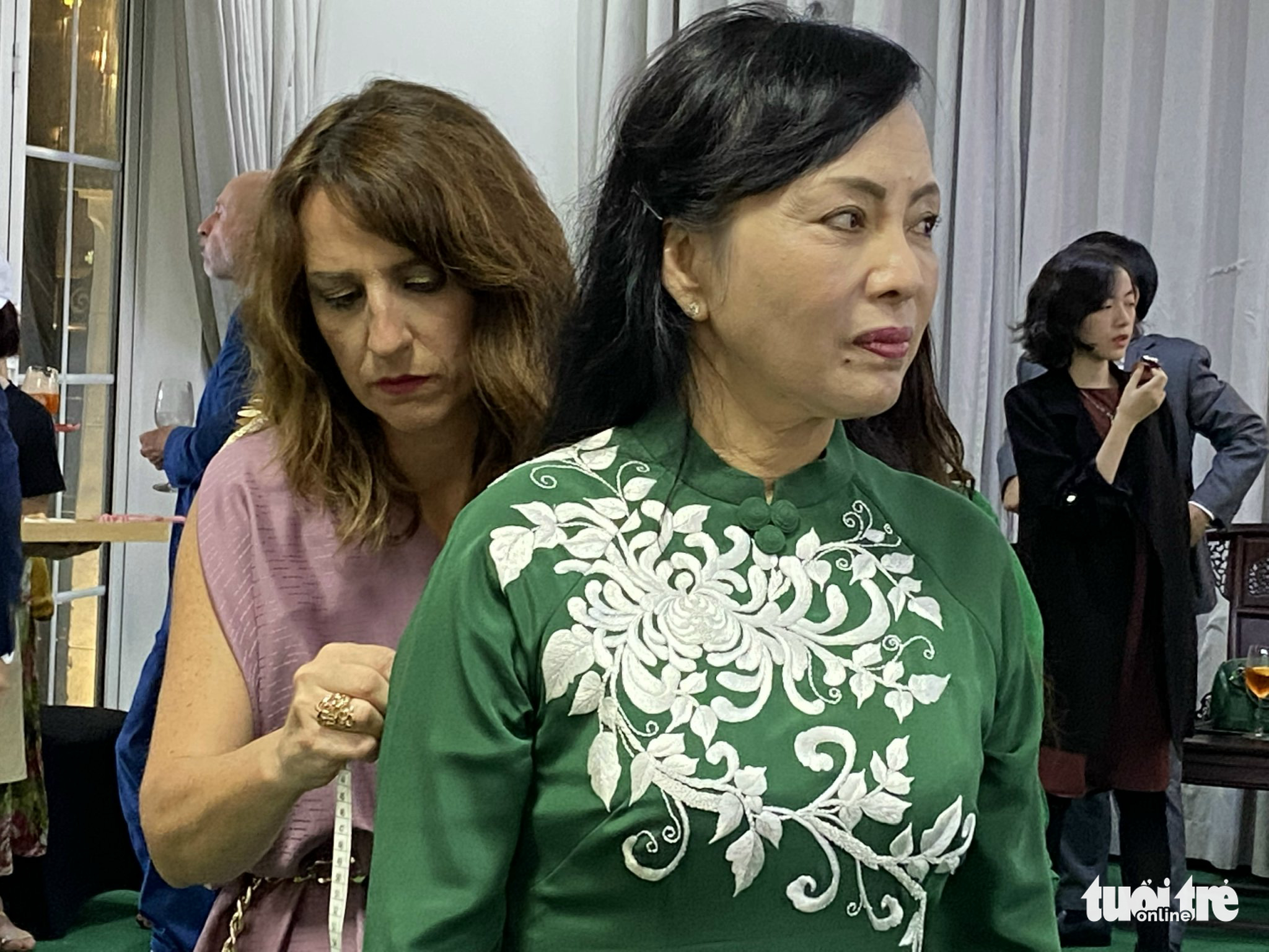 Italian designer Maria Elena takes measurements of former Vietnamese Minister of Health Nguyen Thi Kim Tien. Photo: T. Dieu / Tuoi Tre