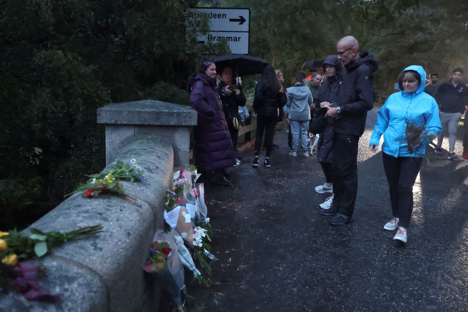 People gather by an entrance to Balmoral Castle, after Queen Elizabeth, Britain's longest-reigning monarch and the nation's figurehead for seven decades, died aged 96, in Balmoral, Scotland, Britain September 8, 2022. Photo: Reuters