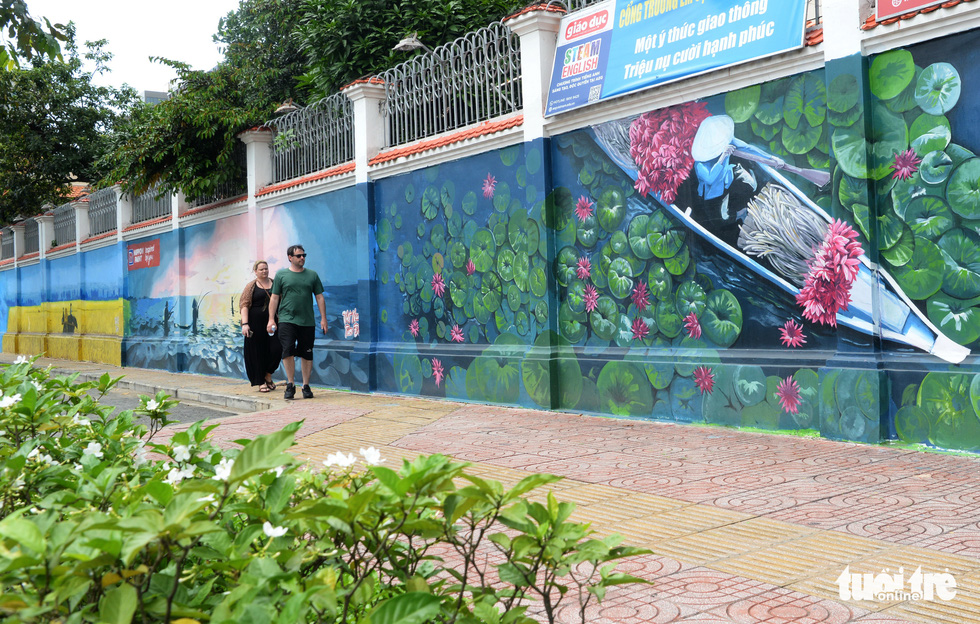 To hide graffiti on a wall along Nguyen Huu Canh Street in District 1, ZKhoa Kama artists have drawn a picture called “Beautiful Vietnam”. Photo: T.T.D. / Tuoi Tre