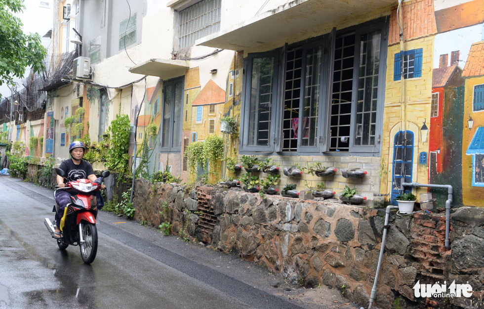 A wall along an alley on Nguyen Binh Khiem Street in District 1 is covered with nice paintings and tree planters. Photo: T.T.D. / Tuoi Tre
