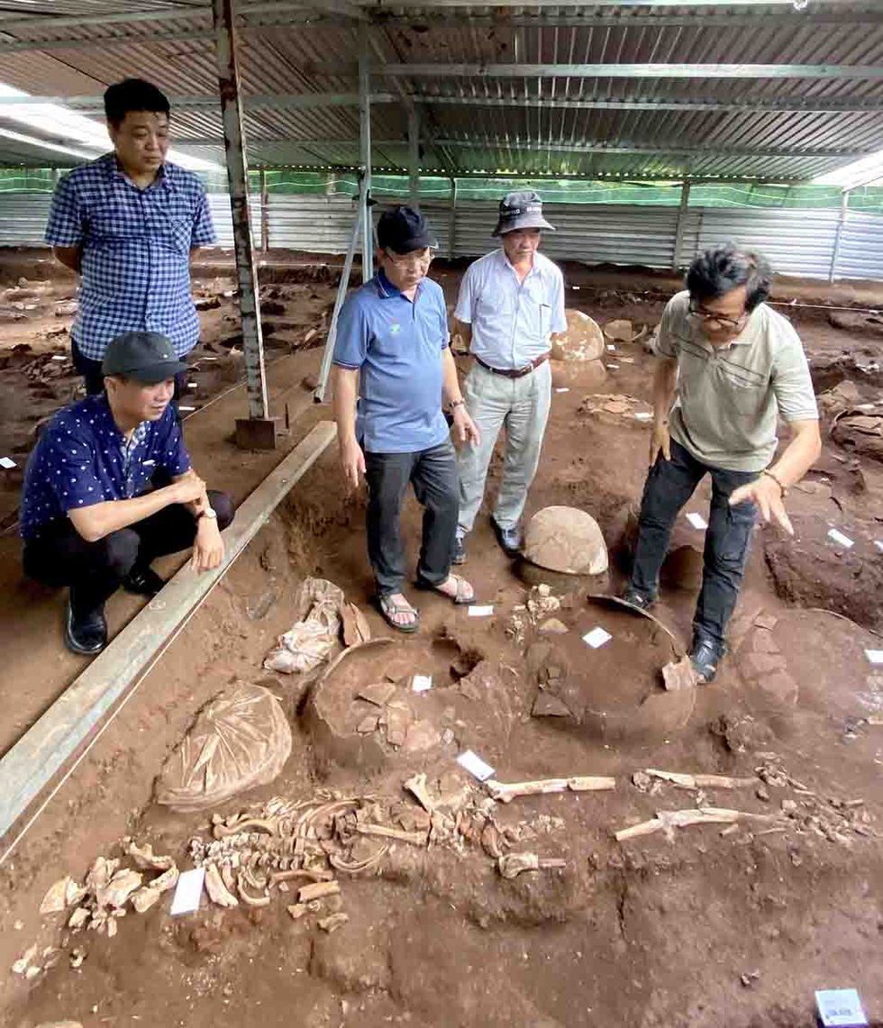 Dang Van Thang (right) introduces the remains of the ancient man in Can Gio District to Tran The Thuan (right, 3rd), director of the Ho Chi Minh City Department of Culture and Sports. Photo: L.Dien / Tuoi Tre