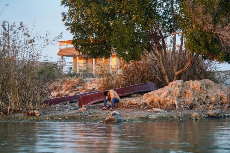 Threatened Eden: a young man bows his head on the banks of the Shatt al-Arab in southern Iraq. Photo: AFP