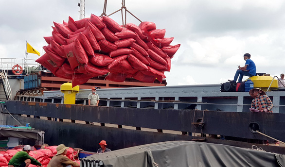 Workers load bags of rice onto a vessel at the My Thoi Port in Long Xuyen City, An Giang Province. Photo: Buu Dau / Tuoi Tre
