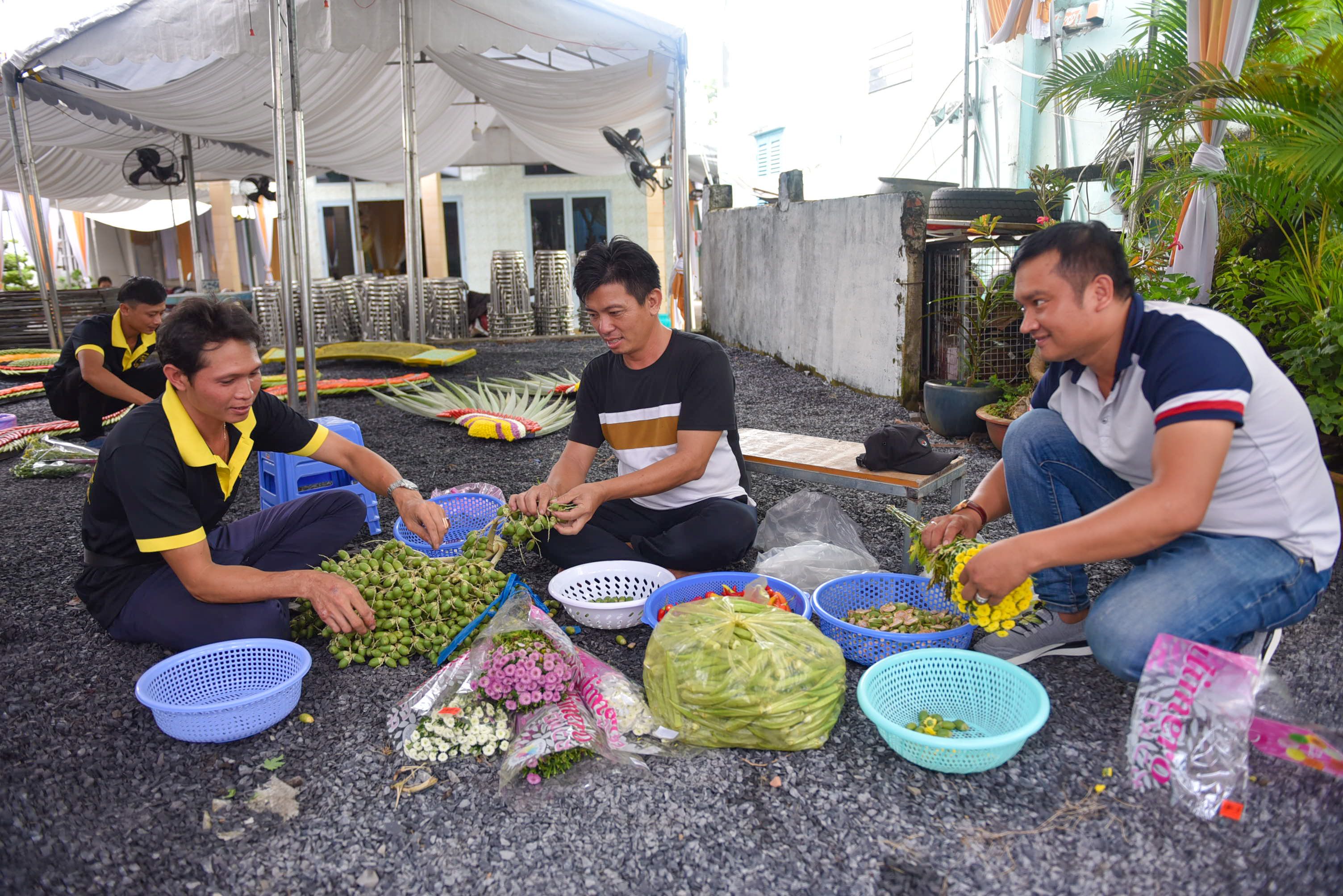 Tran Trung Hieu (center) and his team are working on the flowers and betel nuts for a wedding gate in District 12, Ho Chi Minh City. Photo: Ngoc Phuong / Tuoi Tre News.