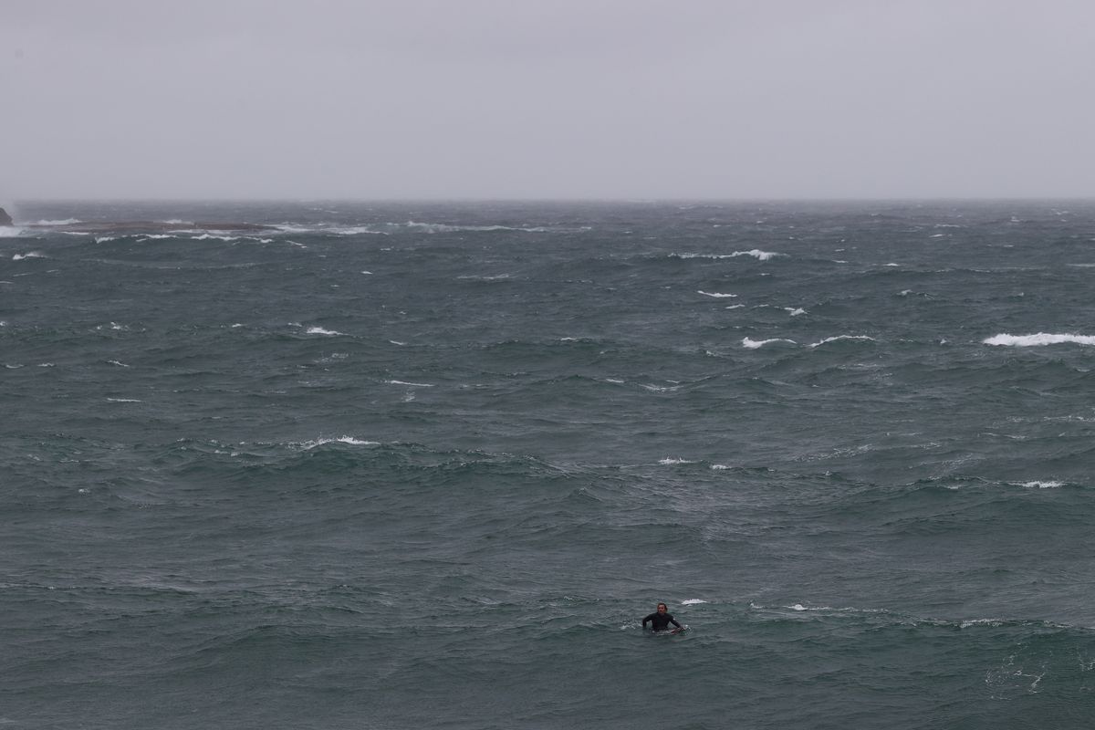 A surfer paddles through large waves in stormy weather at Coogee Beach as heavy rains affect Sydney, Australia, October 6, 2022. Photo: Reuters