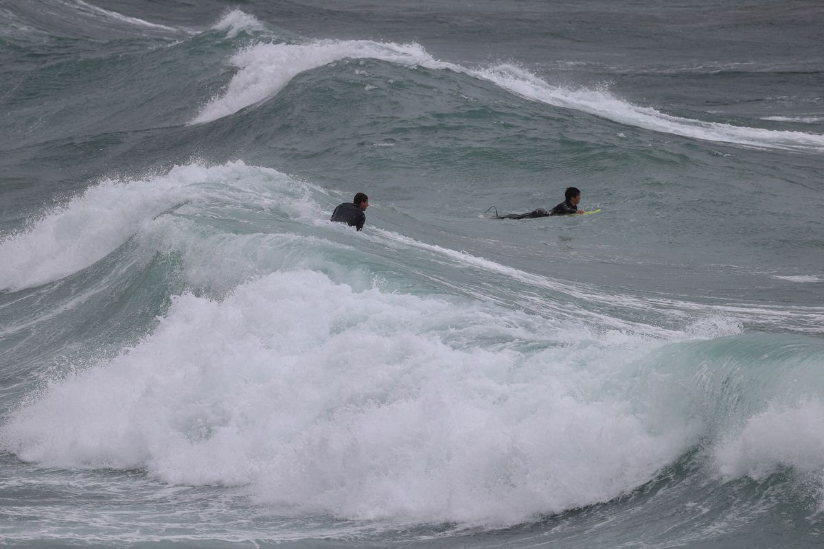 Surfers paddle through large waves in stormy weather at Coogee Beach as heavy rains affect Sydney, Australia, October 6, 2022. Photo: Reuters