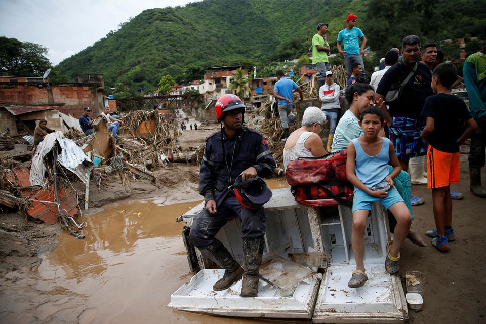 A rescue member and locals rest following a landslide due to heavy rains, in Las Tejerias, Aragua state, Venezuela October 9, 2022. Photo: Reuters