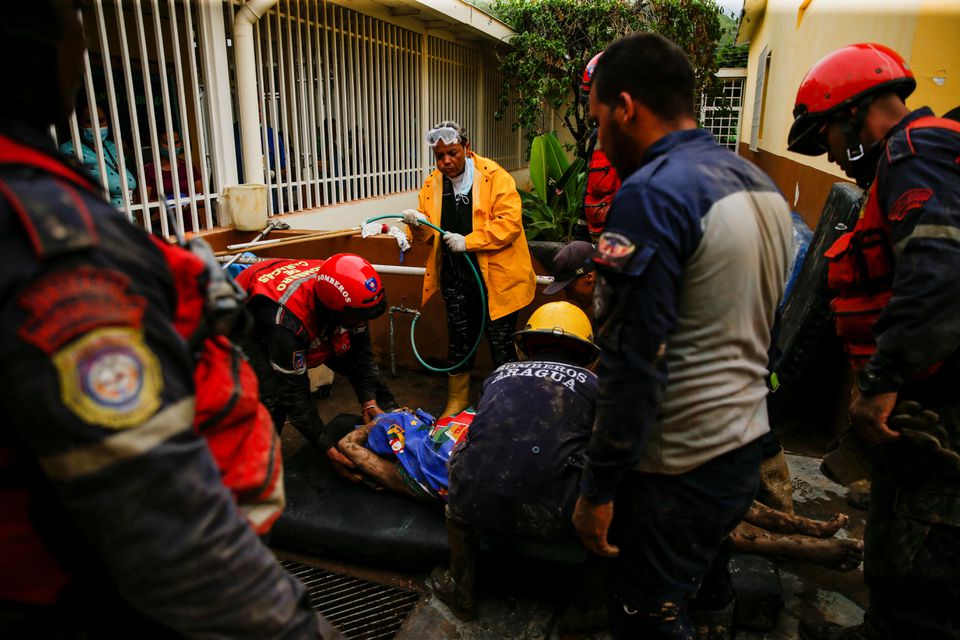 Rescue members carry the body of a person that died during a landslide, following floods due to heavy rains, in Las Tejerias, Aragua state, Venezuela October 9, 2022. Photo: Reuters