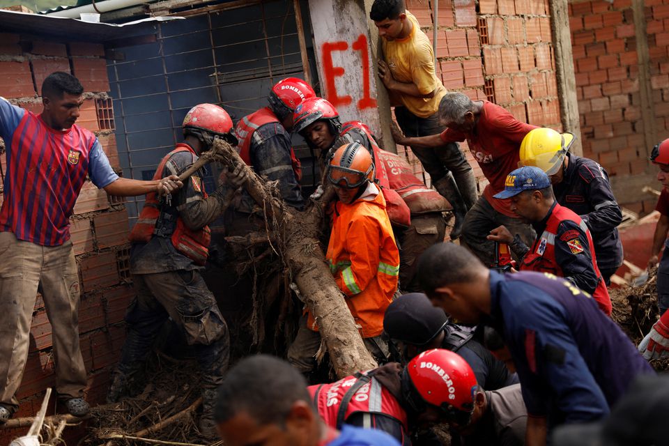 Firefighters work to remove a tree branch following floods due to heavy rains, in Las Tejerias, Aragua state, Venezuela October 9, 2022. Photo: Reuters