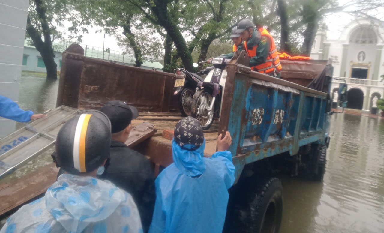 Authorities help people travel through a heavily flooded street in Quang Nam Province, Vietnam, October 10, 2022. Photo: P.M. / Tuoi Tre