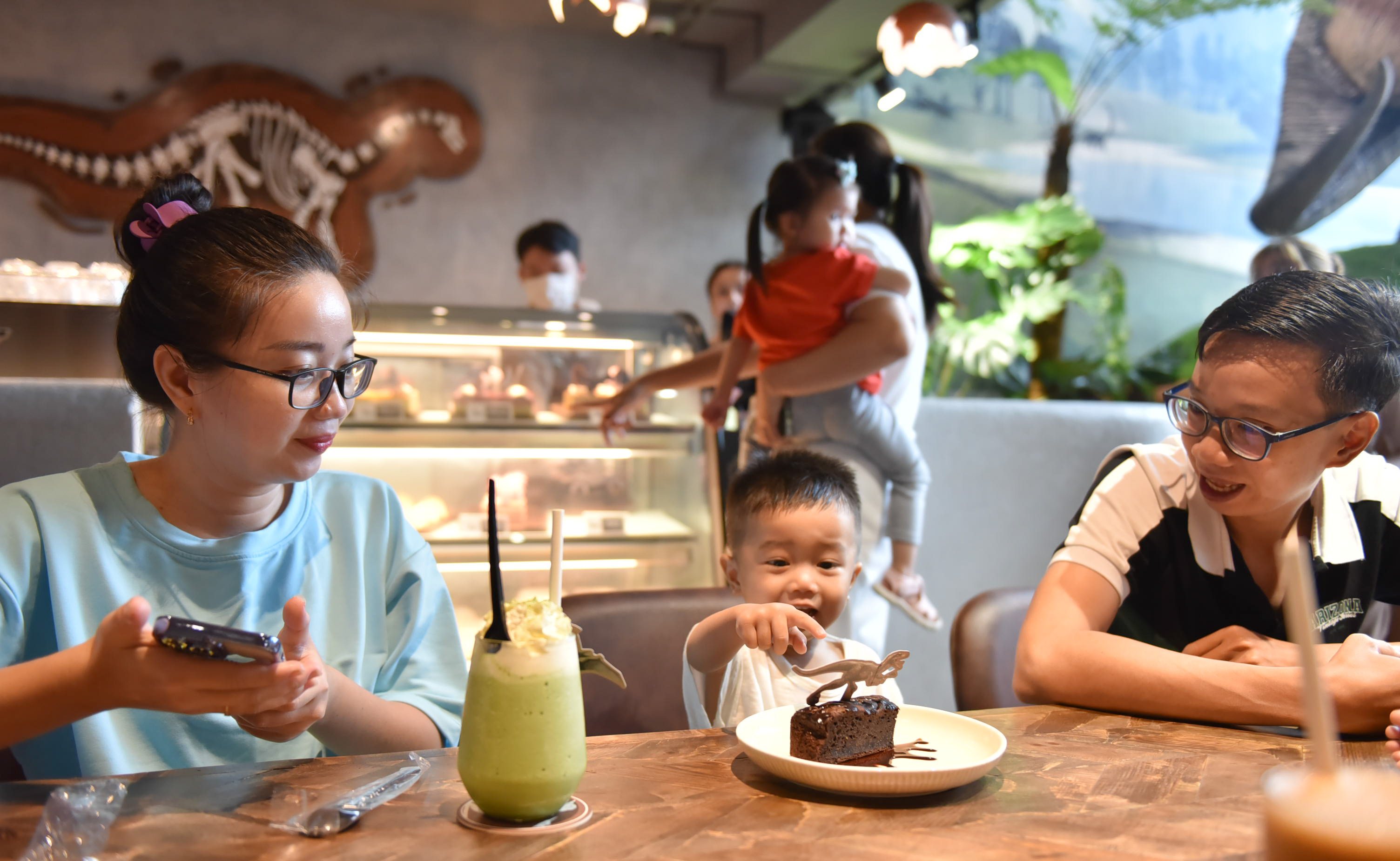 A little boy reacts to seeing a dinosaur on his cake at SAURUS Coffee & Gallery in Go Vap District, Ho Chi Minh City. Photo: Ngoc Phuong / Tuoi Tre News