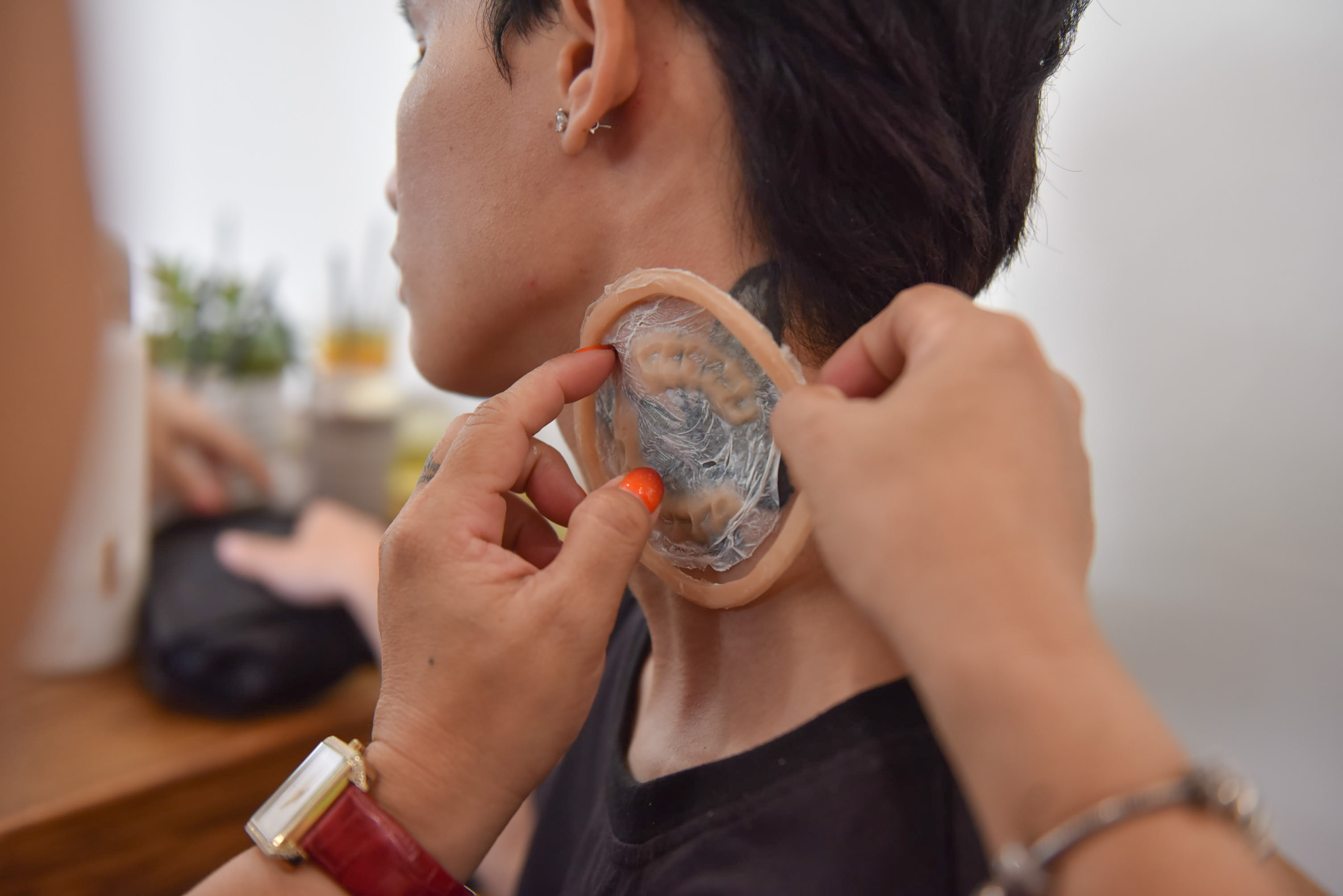 Hang attaches a piece of silicon to mimic a zombie bite on an actor’s neck. Photo: Ngoc Phuong / Tuoi Tre News