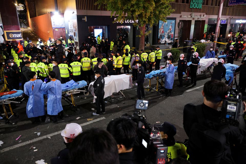Rescue team members wait with stretchers to remove bodies from the scene where dozens of people were injured in a stampede during a Halloween festival in Seoul, South Korea, October 29, 2022. Photo: Reuters