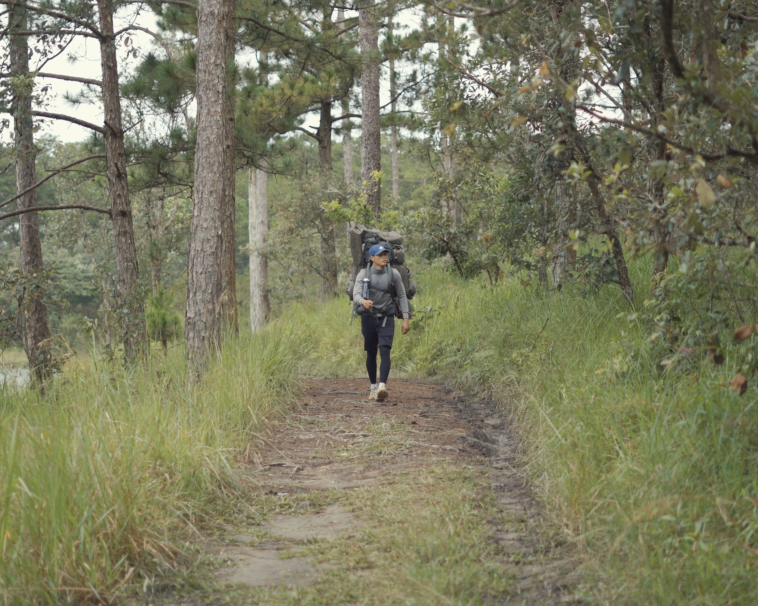 A supplied photo shows Lu Hoang Thong carrying his camping gadgets while walking into the forest alone.