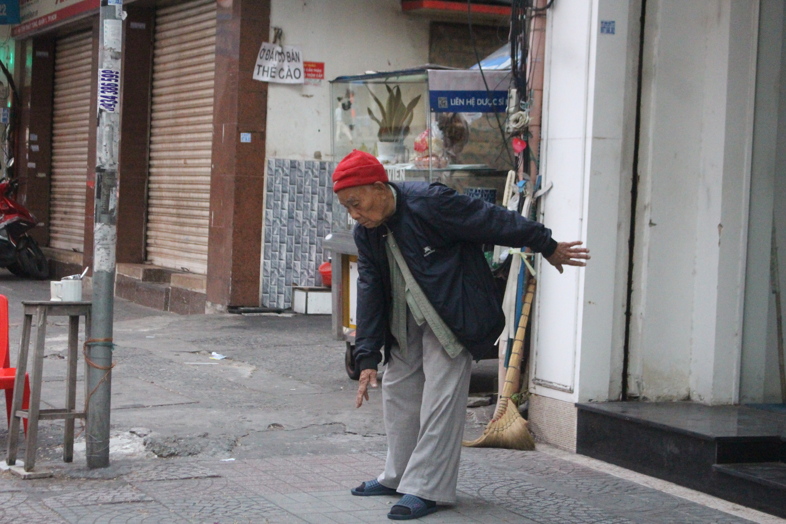 An elderly resident wears warm clothes while exercising in front of a house in Ho Chi Minh City, December 25, 2022. Photo: Tuoi Tre