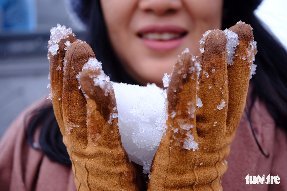  A tourist makes a ball of snow. Photo: Nam Tran / Tuoi Tre