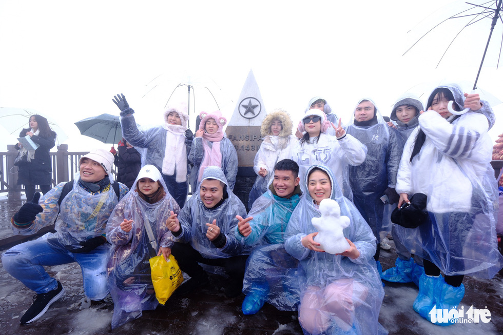  Tourists pose with a snowman atop Fansipan Mountain. Photo: Nam Tran / Tuoi Tre
