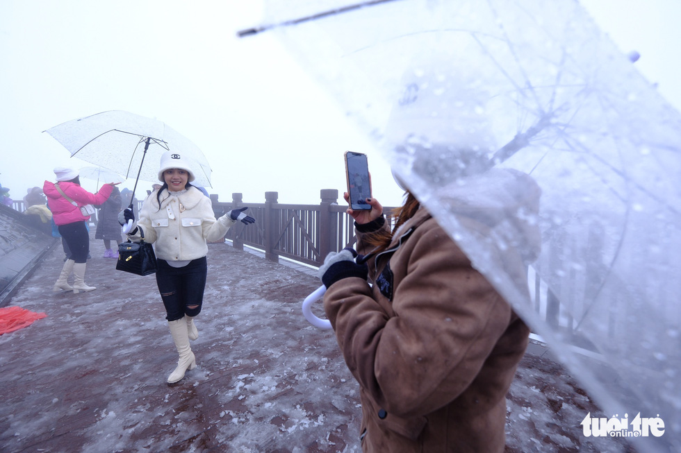  Many young people are excited to take photos in the snown on Fansipan Mountain. Photo: Nam Tran / Tuoi Tre
