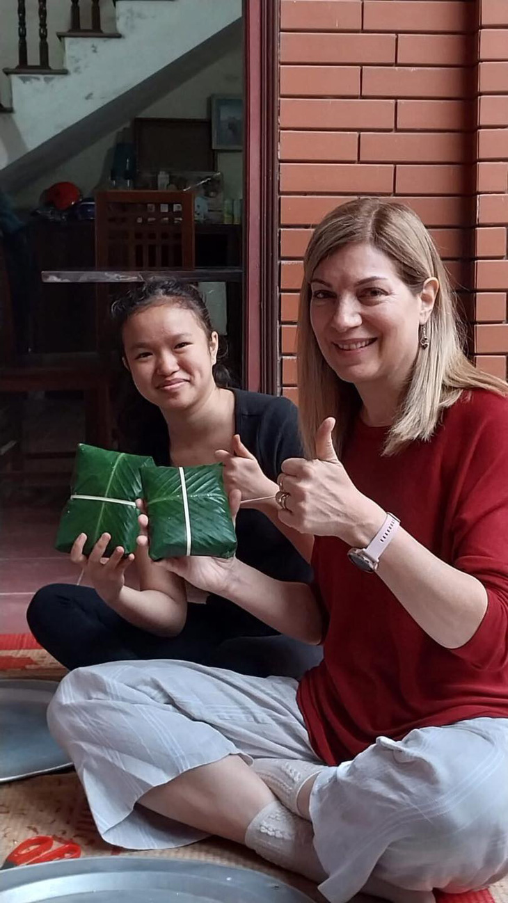 An officer of the Embassy of Canada in Vietnam makes banh chung with a Vietnamese woman. Photo: Embassy of Canada in Vietnam