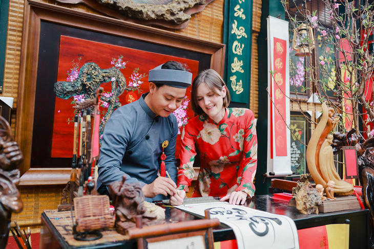 British Consul General to Ho Chi Minh City Emily Hamblin (right) draws calligraphy at the calligraphy street in Ho Chi Minh City. Photo: UK in Vietnam