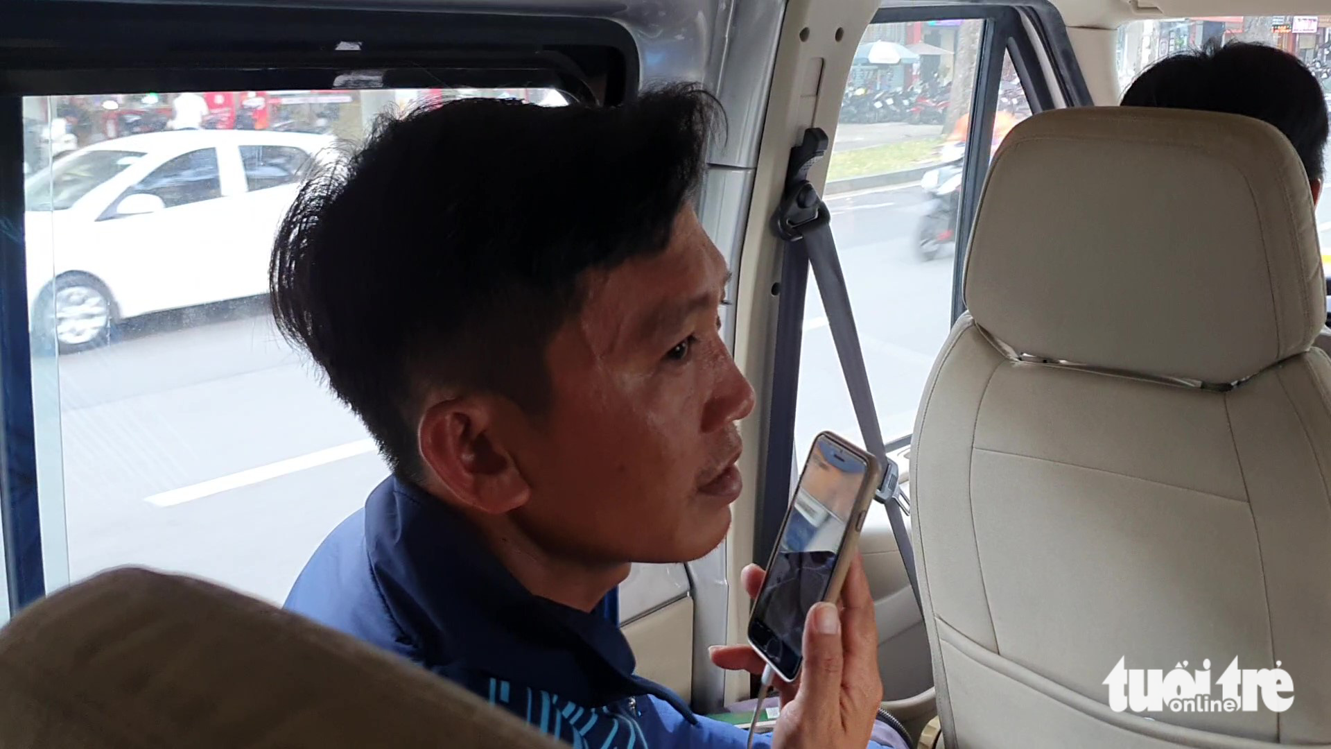 Lieutenant Colonel Nguyen Chi Thanh from the Ho Chi Minh City Firefighting Police talks with his wife on the phone on the way to the airport. Photo: Minh Hoa / Tuoi Tre