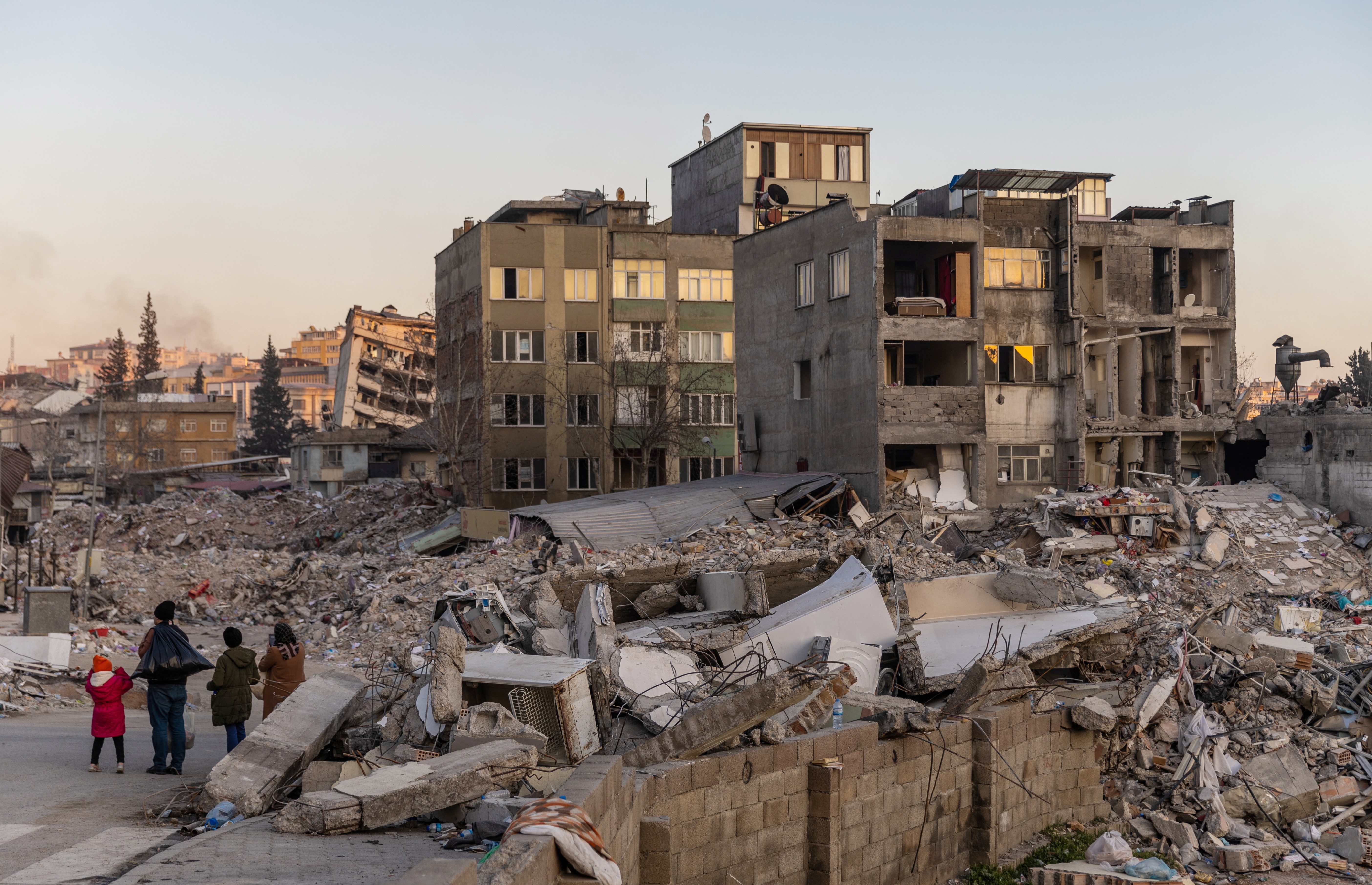 People look at damaged buildings and piles of rubble in the aftermath of a deadly earthquake in Kahramanmaras, Turkey, February 17, 2023. Photo: Reuters