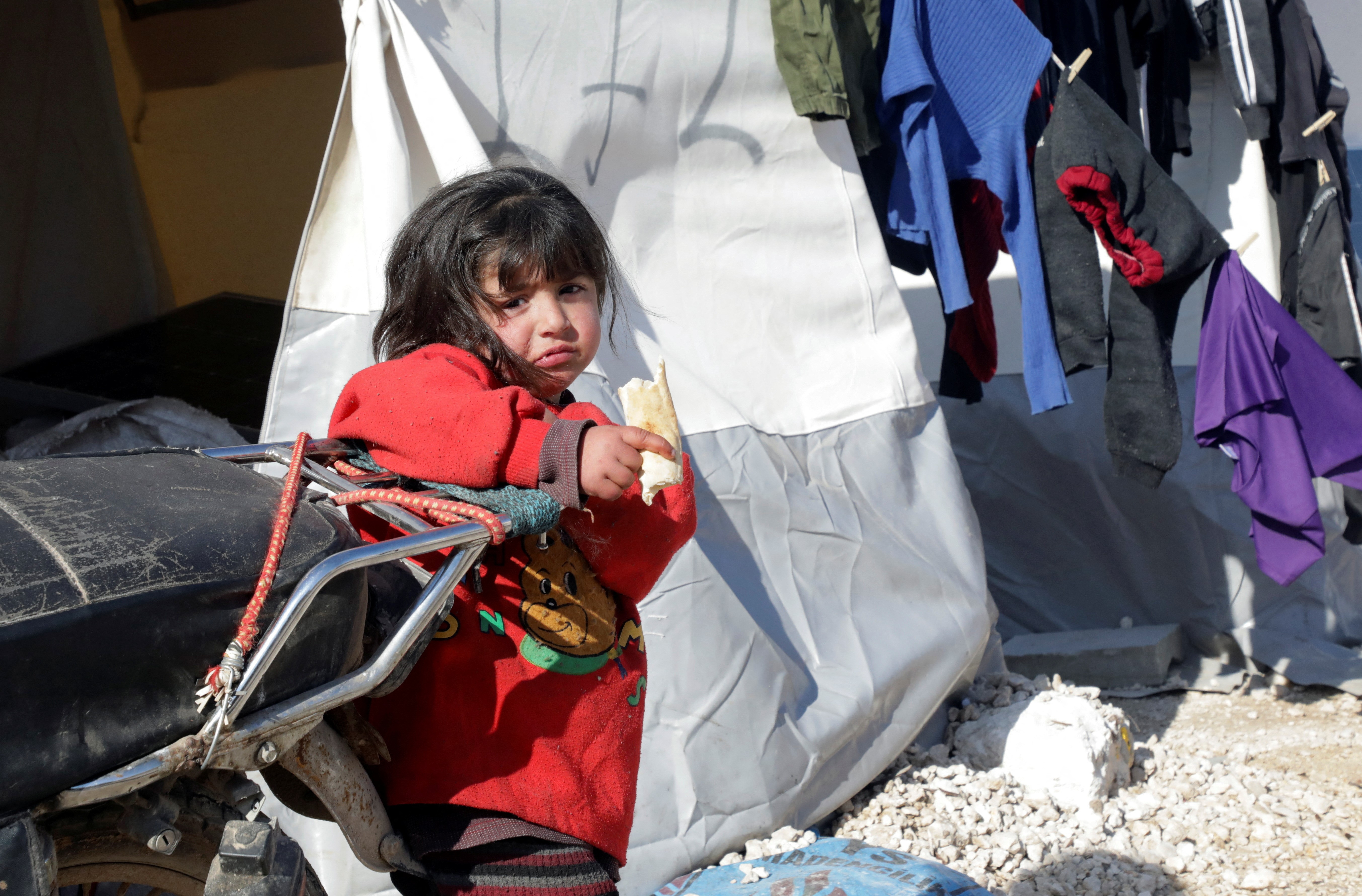 A girl stands outside a tent at a camp for earthquake survivors, on the outskirts of rebel-held town of Jandaris, Syria February 17, 2023. Photo: Reuters